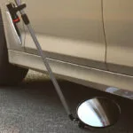 Miroir d’inspection sous véhicule avec poignée télescopique et roulettes, utilisé pour la sécurité et la détection d’objets sous les voitures.